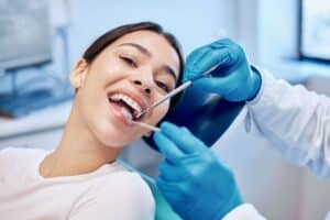 Woman smiling in dentist chair getting dental crowns placed in McLean, VA