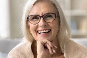 Older woman smiling with complete smile from dental implants in McLean, VA