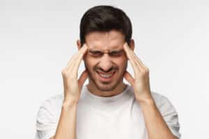 Man holding his head in pain due to dental-related migraine in McLean, VA